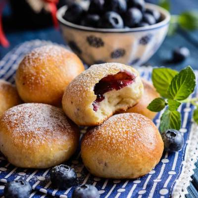 Drożdżowe bułeczki z jagodami posypane cukrem pudrem