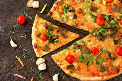 Pizza z wypieczonym ciastem, mozzarellą i świeżymi dodatkami podana w pizzerii