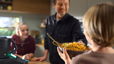 Wspólne gotowanie z dziećmi w domu – ferie w kuchni z robotem kuchennym Dzieci gotujące z tatą w kuchni z pomocą robota kuchennego podczas ferii w domu