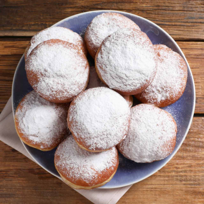 Tradycyjne pączki drożdżowe z nadzieniem, oprószone cukrem pudrem