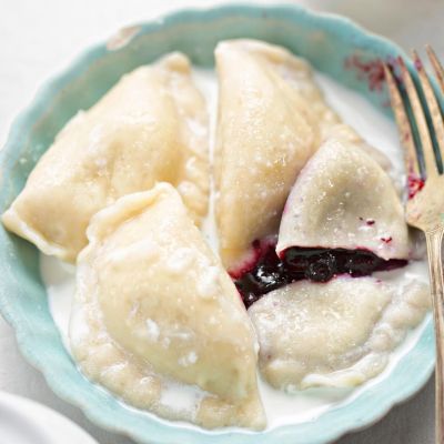 Pierogi z jagodami – domowy przepis Pierogi z jagodami polane śmietaną i posypane cukrem