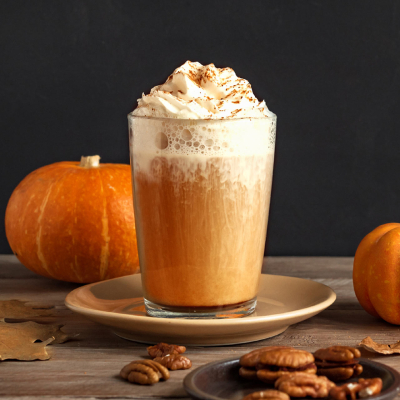 Szklanka kawy Pumpkin Spice Latte z bitą śmietaną i posypką cynamonową