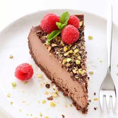 Sernik czekoladowy z posypką pistacjową i malinami