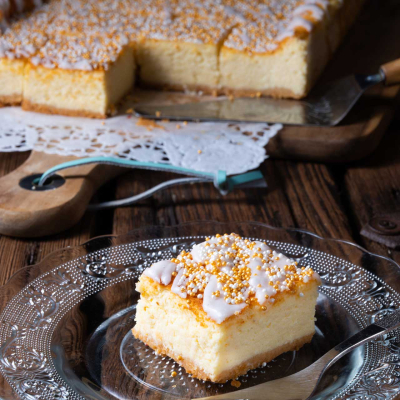 Sernik z mlekiem skondensowanym, polany lukrem i udekorowany kolorową posypką cukrową