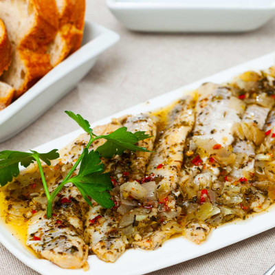 Śledzie z suszonymi pomidorami podane na wigilijnym stole