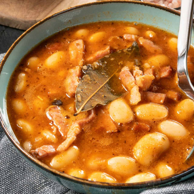 Zupa grochowa z boczkiem i kiełbasą, gęsta i aromatyczna, podana w misce z kromką chleba